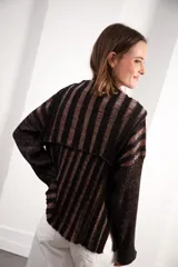 Buzo color beige con rayas horizontales en lurex dorado, cuello con medio cierre, corte oversized y logo tejido en el puño.