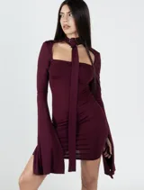 Vestido corto color borgoña, ajustado al cuerpo, con escote recto, mangas largas acampanadas y gargantilla con hebilla plateada.