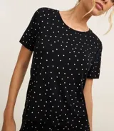Camiseta de pijama negra con estampado de lunares blancos, cuello redondo y mangas cortas.