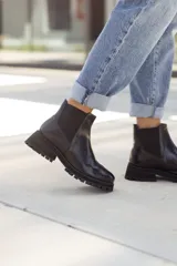 Botas negras de cuero con diseño chelsea y suela chunky, que proporcionan comodidad y estilo.