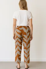 Pantalón marrón con estampado de hojas en blanco y celeste, de corte recto y cintura elastizada.