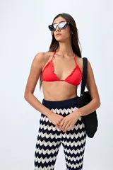 Top de bikini blanco con tirantes finos ajustables al cuello y a la espalda. Presenta volados en el escote y está confeccionado en tejido suave con acabado elástico.