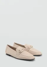 Mocasín de cuero color camel con punta fina y detalle de hebilla metálica dorada.