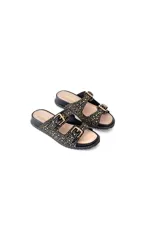 Sandalias planas negras de cuero con tachas doradas y plateadas, dos correas ajustables con hebillas metálicas y plataforma baja.