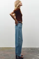 Jersey de punto negro, cuello redondo y manga corta, con acabados en rib en cuello, puños y ruedo.