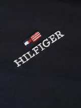 Buzo azul marino con capucha y cordón ajustable, de corte regular. Presenta el logo de Tommy Hilfiger bordado en el pecho y la bandera de la marca en el puño.
