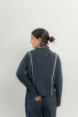 Saco de lana italiano azul con cuello en V, cierre con botones y ribetes en contraste.