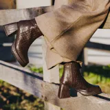 Botas cortas de cuero negro, con cierre lateral, taco de madera forrado en cuero y suela de goma.