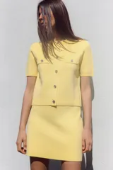 Minifalda amarilla de punto liso, tiro alto, cintura elástica y corte evasé.
