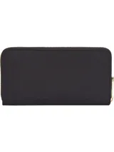 Billetera grande Tommy Hilfiger negra con cierre de cremallera y logo dorado de la marca en el frente. Cuenta con múltiples ranuras interiores para tarjetas, dos compartimentos para billetes y un bolsillo interior con cremallera.