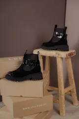 Botas de cuero color marrón oscuro, estilo Chelsea, con elástico lateral negro y suela track negra. Incluye correa de cuero desmontable con hebilla.