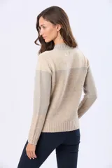 Buzo tejido con diseño de bloques de color en rosa, gris claro y beige. Posee un cuello alto y corte holgado.