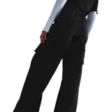 Pantalón negro de corte ancho con bolsillos cargo laterales y logo de Nike bordado en blanco.