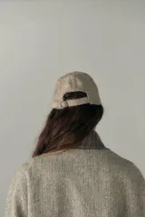 Gorra con visera de lana color beige con diseño de espiga.