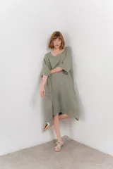 Vestido midi color verde oliva, de lino, con corte holgado, mangas 3/4 y escote redondo.
