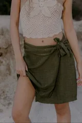 Minifalda verde oliva de lino y poliéster, con corte cruzado y lazo lateral.