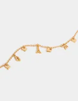 Collar corto dorado con cadena de eslabones y dijes colgantes: moño, zapatos de ballet, corazón y la Torre Eiffel.