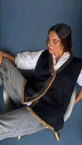 Chaleco tejido a mano con escote en V, bordado con botones, confeccionado en algodón con detalles de lurex. Terminaciones en crochet y bordados hechos a mano con lana merino.