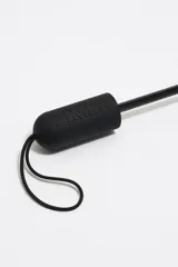 Paraguas plegable con funda textil estampada en tonos pastel con motivos paisley y flores. El mango es de plástico color verde lima y tiene una correa de sujeción a juego.