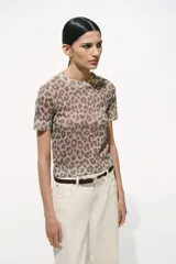 Remera de punto fino color beige con estampado de leopardo, cuello redondo y mangas cortas.