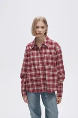 Camisa a cuadros roja y blanca, de corte holgado y manga larga.