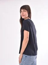 Remera color crudo con estampado de un pez rojo en el frente.