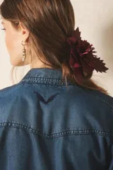 Camisa de manga larga confeccionada en tencel, color azul denim, de corte clásico, con cuello camisero, bolsillos en el frente y botones metálicos.