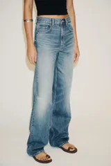 Pantalón de jean azul oscuro, de tiro alto, corte wide leg y largo hasta el tobillo.