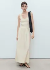 Vestido midi color crudo, de corte evasé, con breteles anchos y escote redondo.