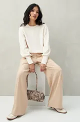 Sweater color crudo de tejido tramado, con mangas abullonadas y puños elastizados.