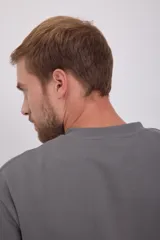 Buzo gris de manga larga y cuello redondo, con corte holgado y tejido de felpa suave.