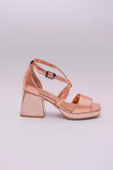 Sandalias de cuero color cobre con plataforma y taco cuadrado. Tiras cruzadas sobre el empeine y pulsera con hebilla al tobillo.