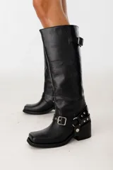 Bota de caña alta de cuero negro con punta cuadrada y estribo desmontable.