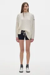 Sweater tejido color borgoña con cuello alto, corte oversize y mangas largas con detalle de trenzas verticales.
