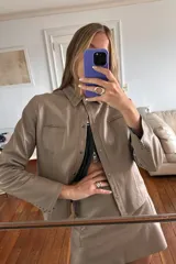 Camisa de cuero color visón con tachas oro empavonadas en cuello, bolsillos y mangas.