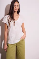 Remera blanca de algodón con cuello en V y bordado de flores caladas.