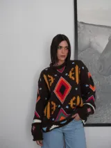 Sweater tejido de lana color azul marino con diseño geométrico en blanco.