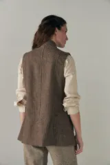 Chaleco color beige, entallado, con solapa, bolsillos plaqué y terminaciones envivadas.