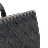Mochila negra de poliéster con diseño tejido formando rombos. Tiene formato rectangular, acceso con cierre, correa regulable y asa fija. Cuenta con un bolsillo interno con cierre y dos abiertos, herrajes plateados, un compartimento y logo de XL Extra Large al frente en símil cuero.