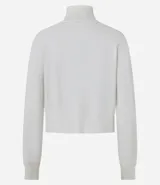 Blusa de punto color blanco, con cuello alto, manga larga y diseño liso.