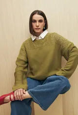 Sweater de punto color salmón con cuello redondo y mangas anchas. Presenta un diseño calado en la parte superior y tejido tramado horizontal en el resto del cuerpo.