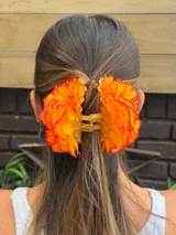 Pinza para el pelo con flores rojas de tela.