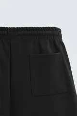 Bermuda azul de corte relaxed fit, confeccionada en tejido interlock de algodón con cintura elástica ajustable con cordón, bolsillos laterales y bolsillo trasero de plastrón.