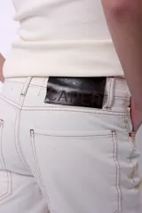 Jean de denim 100% algodón, de tiro medio y corte wide leg. Color blanco con efecto de lavado y manchas en tonos beige y marrón.