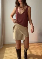 Minifalda cruzada color beige de tejido de punto con hebilla de madera. Tejido con hilado italiano de alta calidad con lurex y viscosa.