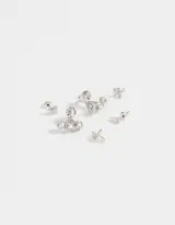Set de tres pares de aros pasantes bañados en plata: un par con forma de alfiler, un par con forma de cruz y un par tipo earjacket con diseño de rosa y strass.