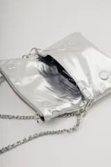 Bandolera plateada de cuero con solapa frontal y correa combinada de cuero y cadena metálica. Incluye una correa desmontable y regulable en cuero con eslabones metálicos.