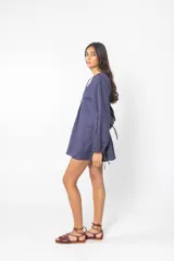 Vestido corto azul con escote con cordones, mangas largas abullonadas y corte evasé.