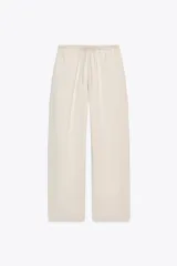 Pantalón ancho color beige, de tiro medio y cintura ajustable con cordones.