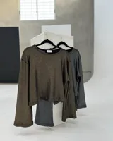 Sweater de tejido de punto calado color dorado, de corte crop y mangas acampanadas.